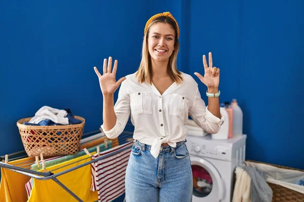 Young Blonde Woman Laundry Room Showing Pointing Fingers Number Eight — Stockfoto