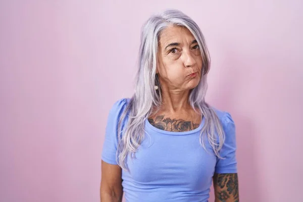 Mulher Meia Idade Com Tatuagens Sobre Fundo Rosa Soprando Bochechas — Fotografia de Stock