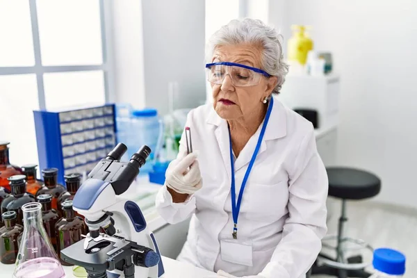 Starsza Siwowłosa Kobieta Mundurze Naukowca Trzymająca Pigułkę Laboratorium — Zdjęcie stockowe