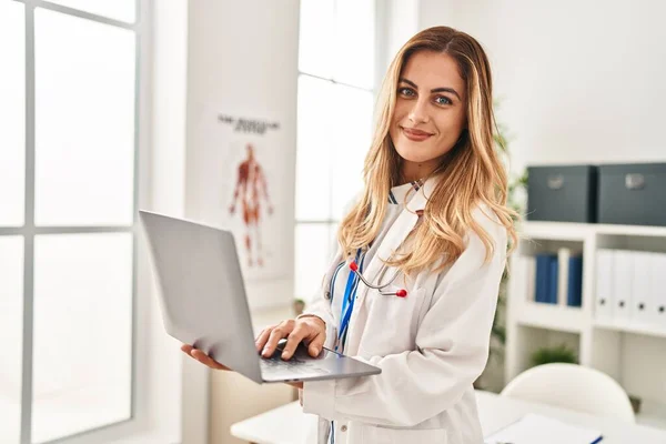 Young Blonde Woman Wearing Doctor Uniform Using Laptop Clinic — Stock Photo, Image
