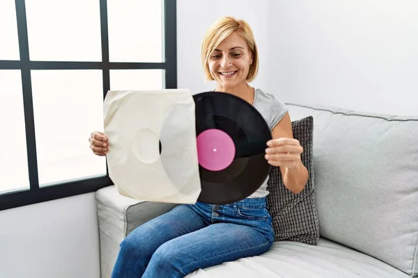 Blonde Frau Mittleren Alters Lächelt Selbstbewusst Und Hält Schallplatte Hause — Stockfoto