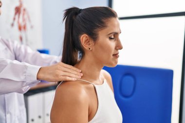 Fizyoterapi kliniğinde boyun masajı yaptıran genç İspanyol kadın.