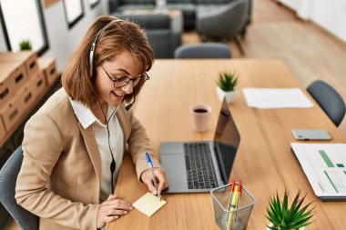 Ofiste çalışırken gülümseyen Kafkasyalı bir çağrı merkezi ajanı..