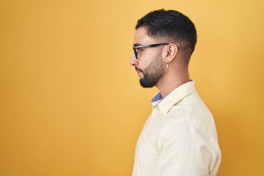 İş elbiseleri ve gözlük takan İspanyol genç bir adam. Taraf arıyor, profil pozu veriyor. Doğal bir yüzü ve kendine güvenen bir gülümsemesi var.. 