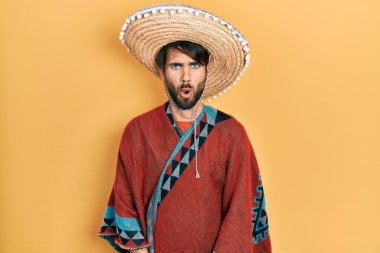 Meksikalı şapkalı genç İspanyol adam. Şaşırmış ve korkmuş bir ifade, korku ve heyecanlı bir yüz ifadesi var.. 
