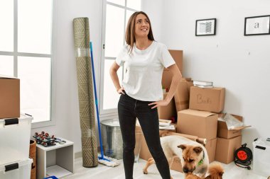 Yeni evinde kendine güvenen genç İspanyol kadın gülümsüyor.