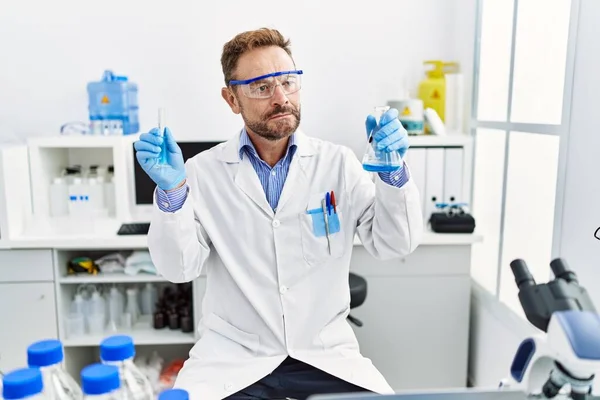 Мужчина Средних Лет Работающий Научной Лаборатории Держит Химические Продукты Улыбаясь — стоковое фото