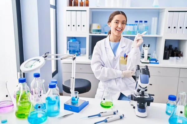 Young Brunette Woman Working Scientist Laboratory Smiling Happy Pointing Hand — Stock Photo, Image