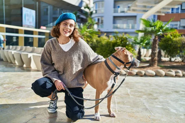 Young caucasian woman smiling confident hugging dog at park