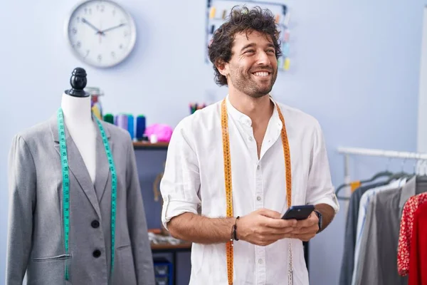 Jovem Hispânico Homem Alfaiate Sorrindo Confiante Usando Smartphone Fábrica Roupas — Fotografia de Stock