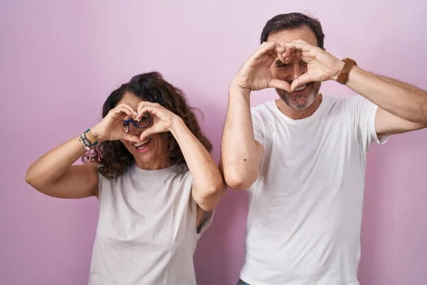 Middle Age Hispanic Couple Together Pink Background Doing Heart Shape — Stockfoto