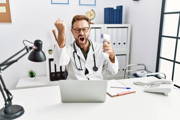 Middle Age Doctor Man Holding Thermometer Clinic Annoyed Frustrated Shouting — Stockfoto