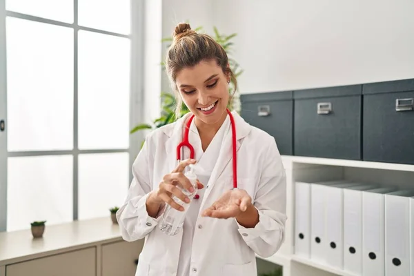 Young Blonde Woman Wearing Doctor Uniform Using Sanitizer Gel Hands — Fotografia de Stock