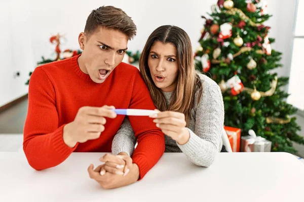 Young couple worried for pregnancy test results. Sitting on the table at home.