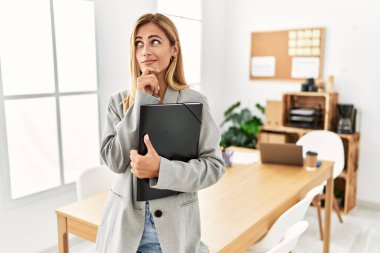 Ofisteki sarışın iş kadını bir soru hakkında endişeli ve gergin olduğunu düşünüyor. 