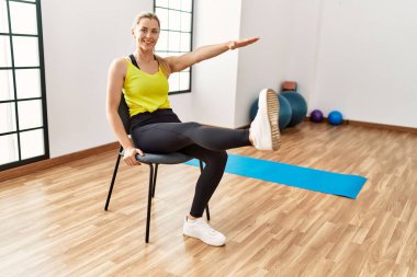 Genç sarışın kız gülümsüyor. Spor merkezinde mutlu antrenmanlar..