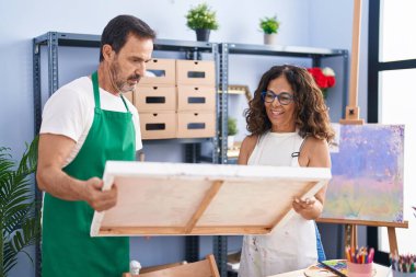 Man and woman artists smiling confident looking draw at art studio
