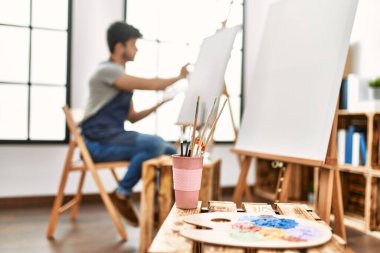 Resim stüdyosunda gülümseyen genç İspanyol ressam..