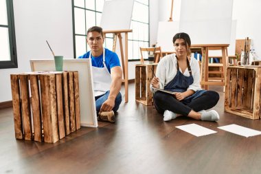 Sanat stüdyosundaki genç İspanyol çift düşüncelere daldı ve ayık ifadeler takındılar. 