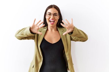 Genç esmer kadın izole edilmiş arka planda duruyor ve 10 numarayı gösterip işaret ederken kendinden emin ve mutlu bir şekilde gülümsüyor.. 