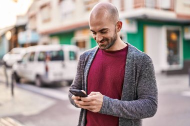 Sokakta akıllı telefon kullanan kendine güvenen genç adam.
