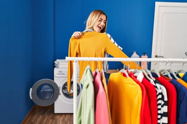 Young Blonde Woman Smiling Confident Holding Clothes Rack Laundry Room — Stok fotoğraf