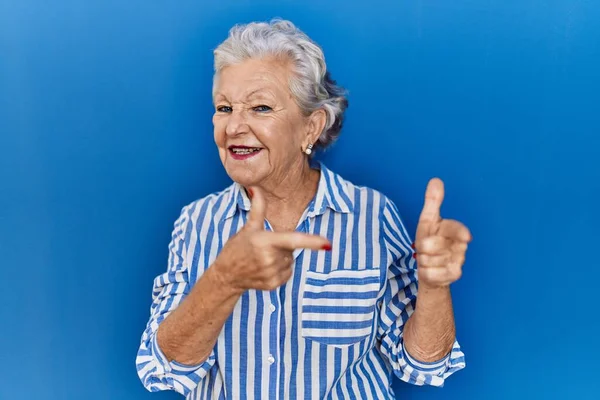 Старша Жінка Сірим Волоссям Стоїть Над Синім Тлом Вказуючи Пальці — стокове фото