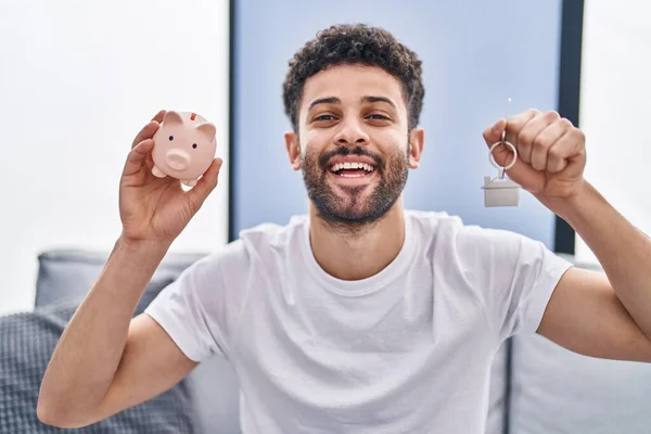 Arabisk Man Håller Spargris Bank Och Hus Nycklar Ler Och — Stockfoto