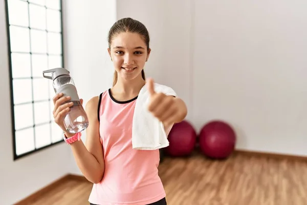 Young Brunette Teenager Wearing Sportswear Holding Water Bottle Approving Doing — Stockfoto