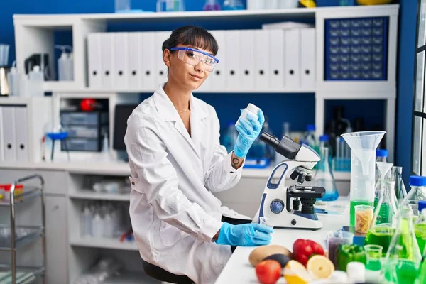 年轻美丽的惊慌失措的女科学家微笑着 自信地拿着药瓶在实验室里 — 图库照片
