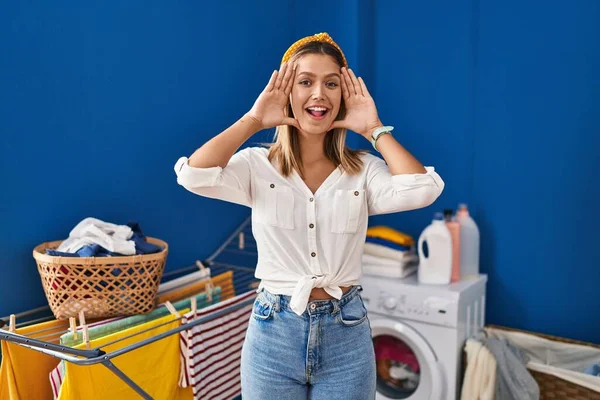 Young Blonde Woman Laundry Room Smiling Cheerful Playing Peek Boo — Stockfoto