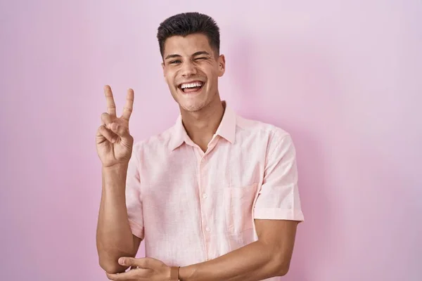 Young Hispanic Man Standing Pink Background Smiling Happy Face Winking — Stok fotoğraf