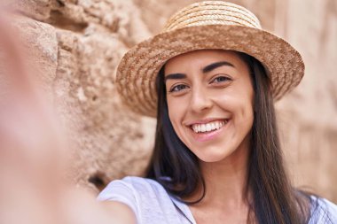 Young hispanic woman tourist smiling confident making selfie by the camera at street