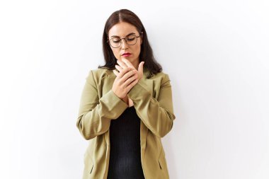 Young brunette woman standing over isolated background suffering pain on hands and fingers, arthritis inflammation 