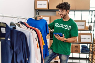 Yardım merkezinde dokunmatik ped kullanan gönüllü üniformalı bir İspanyol genç.