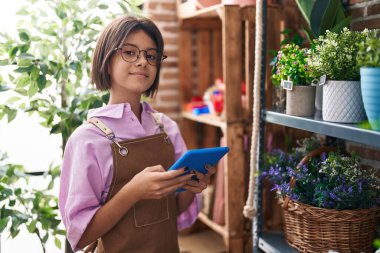 Çiçekçide dokunmatik ped kullanan sevimli İspanyol çiçekçi kız.