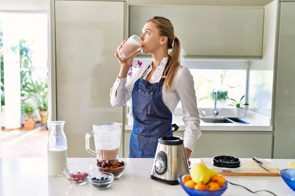 Genç Sarışın Kadın Gülümsüyor Kendine Güveniyor Mutfakta Smoothie Içiyor — Stok fotoğraf