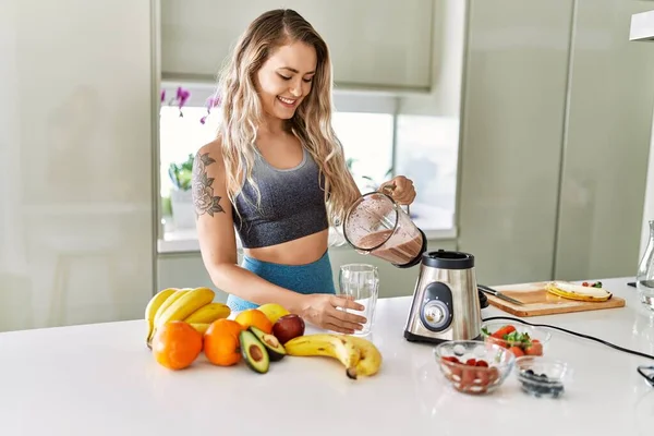 Young Woman Smiling Confident Pouring Smoothie Glass Kitchen — Stok fotoğraf