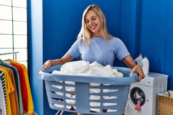 Jonge Blonde Vrouw Glimlachen Zelfverzekerde Holding Mand Met Kleren Wasruimte — Stockfoto