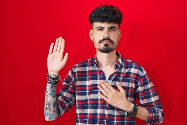 Young Hispanic Man Beard Standing Red Background Swearing Hand Chest — Fotografia de Stock