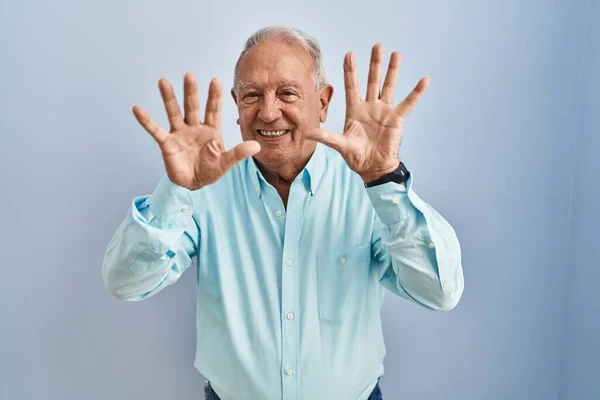 Senior Man Grey Hair Standing Blue Background Showing Pointing Fingers — Stockfoto