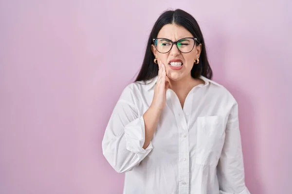 Young Brunette Woman Standing Pink Background Touching Mouth Hand Painful — Stockfoto