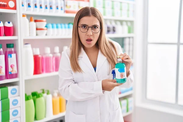 Young Blonde Woman Working Pharmacy Drugstore Holding Syrup Afraid Shocked — Zdjęcie stockowe