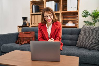 Beyaz kadın psikolog psikoloji merkezinde online danışmanlık yapıyor.