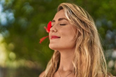 Young woman smiling confident breathing at park