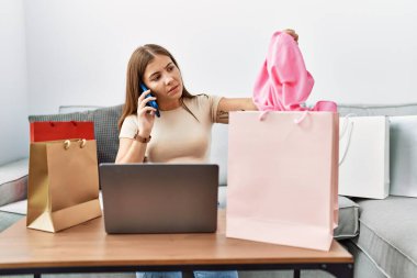 Genç İspanyol kadın akıllı telefondan evde sipariş veriyor.