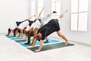 Bir grup genç spor merkezinde esneme hareketleri yapıyor..