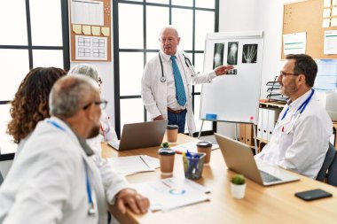 Bir grup orta yaşlı doktor klinikteki bir tıbbi toplantıda tartışıyorlar..