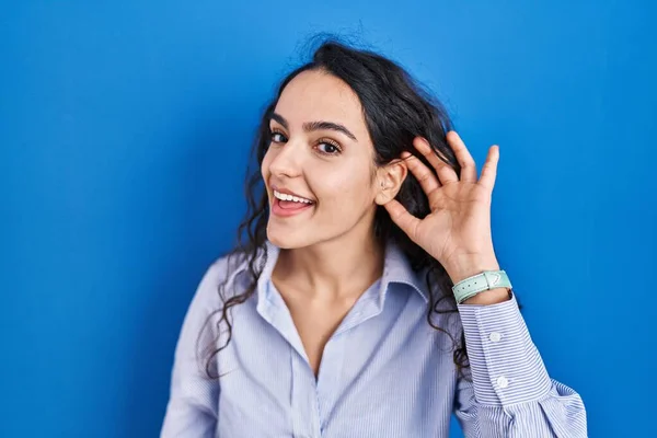 Young Brunette Woman Standing Blue Background Smiling Hand Ear Listening — Foto de Stock
