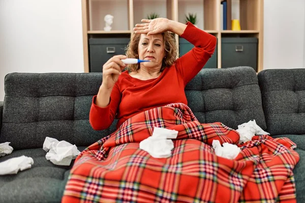中年原因アジアの病気女性測定温度上のソファに自宅で — ストック写真